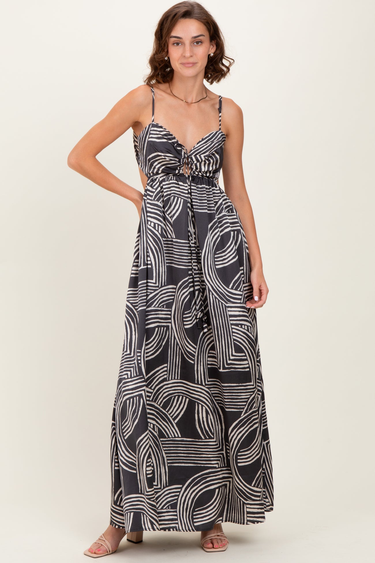 woman wearing a black and white patterned maxi dress with adjustable straps and a drawstring waist
