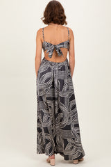 woman wearing a black and white patterned maxi dress with a back tie detail and an open back
