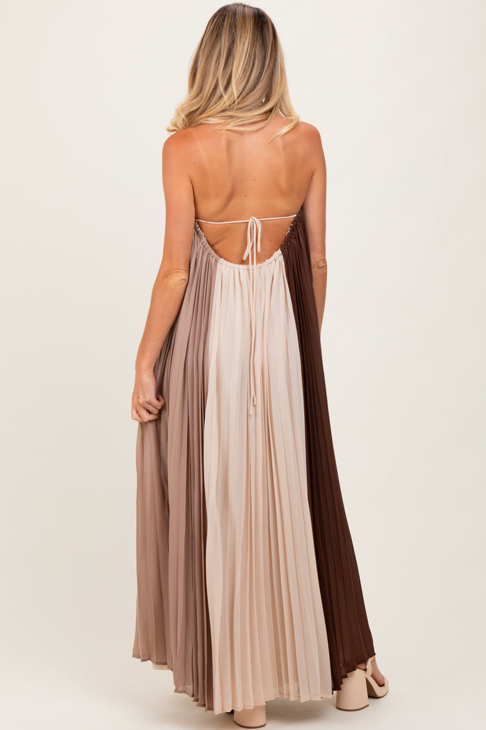 woman wearing a pleated maternity maxi dress in gradient shades of brown and beige, featuring a back tie detail
