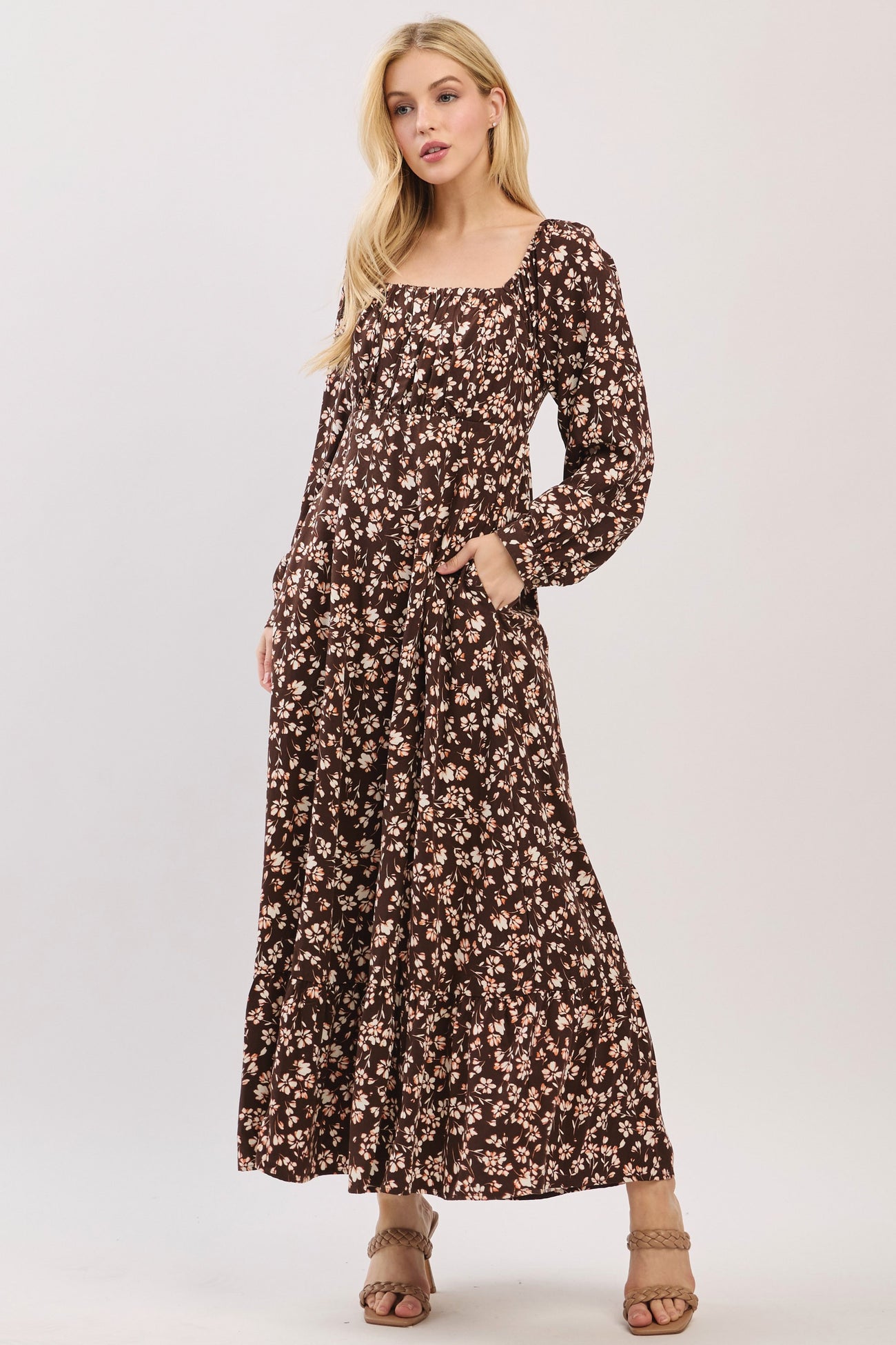 woman wearing a brown floral maxi dress with long sleeves and pockets