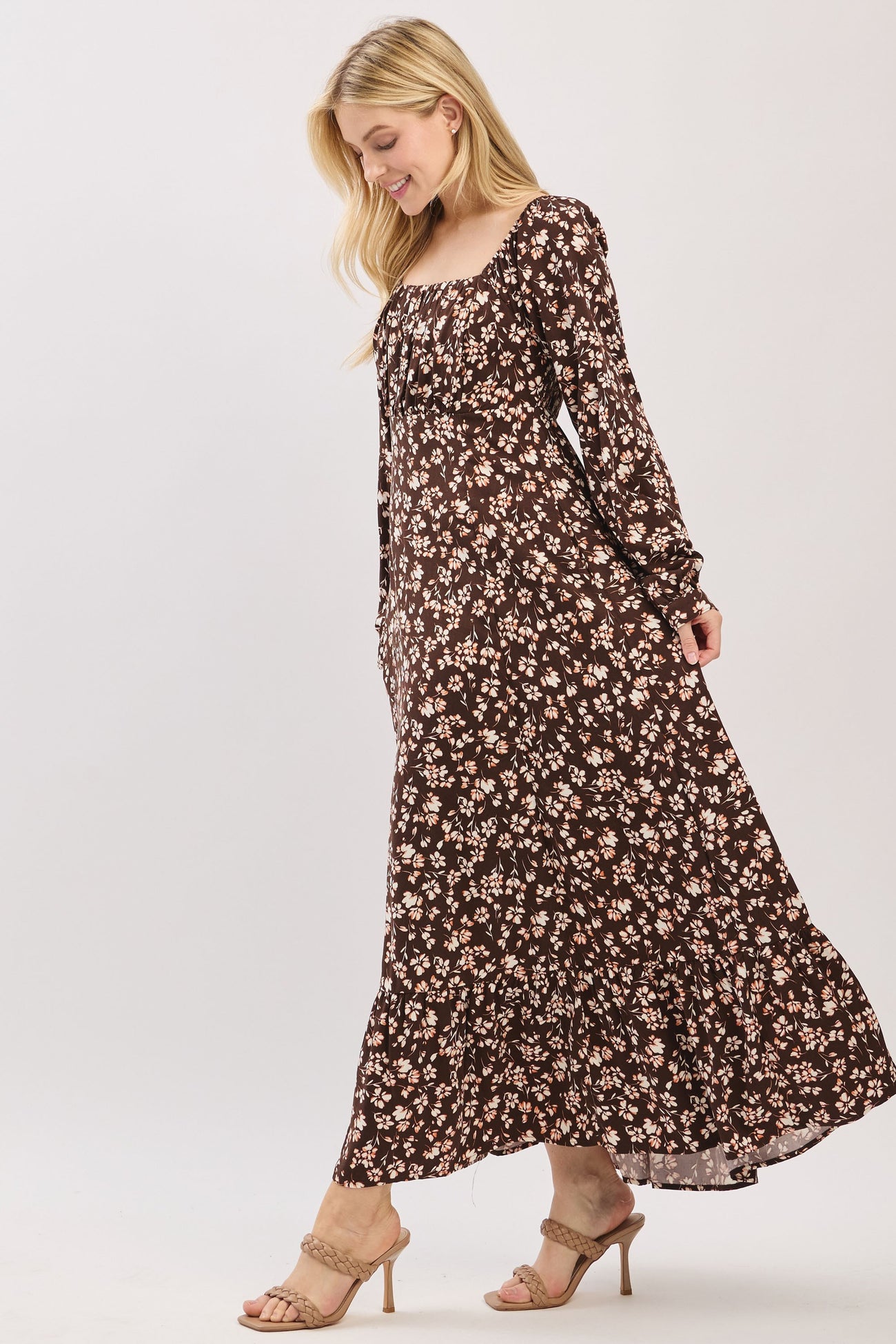 woman wearing a brown floral maxi dress with long sleeves and a square neckline, styled with heels