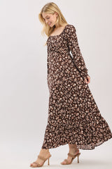 woman wearing a brown floral maxi dress with long sleeves and a square neckline, styled with heels