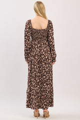 woman wearing a brown floral maxi dress with a smocked back and long sleeves, viewed from the back