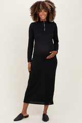 woman wearing a black ribbed maternity dress with a half zipper and a visible baby bump