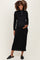 woman wearing a black ribbed maternity dress with a half zipper and a visible baby bump