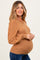 woman wearing a brown maternity sweater with puffed sleeves and a visible baby bump