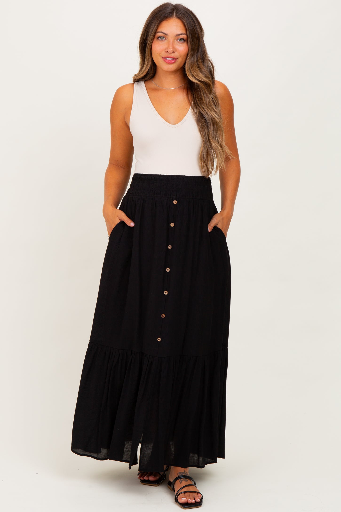 woman wearing a black maternity maxi skirt with pockets and button details
