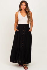 woman wearing a black maternity maxi skirt with pockets and button details