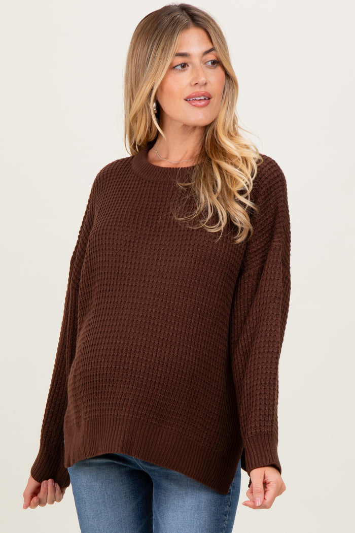 woman wearing a brown textured maternity sweater with a relaxed fit and visible baby bump
