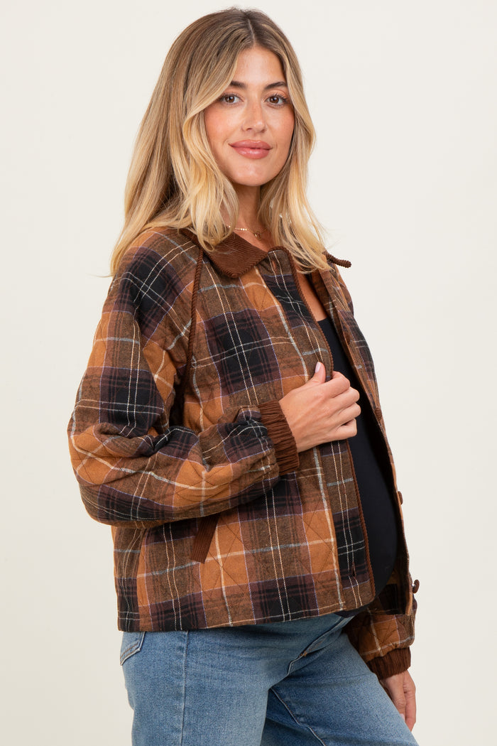 woman wearing a brown plaid maternity jacket with a collar, styled with a black top and jeans, showing her baby bump