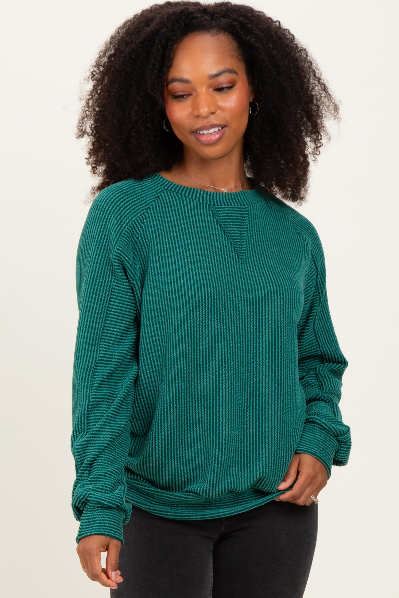 woman wearing a green ribbed long sleeve sweatshirt with a crew neck and relaxed fit