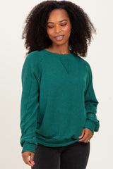 woman wearing a green ribbed long sleeve sweatshirt with a crew neck and relaxed fit