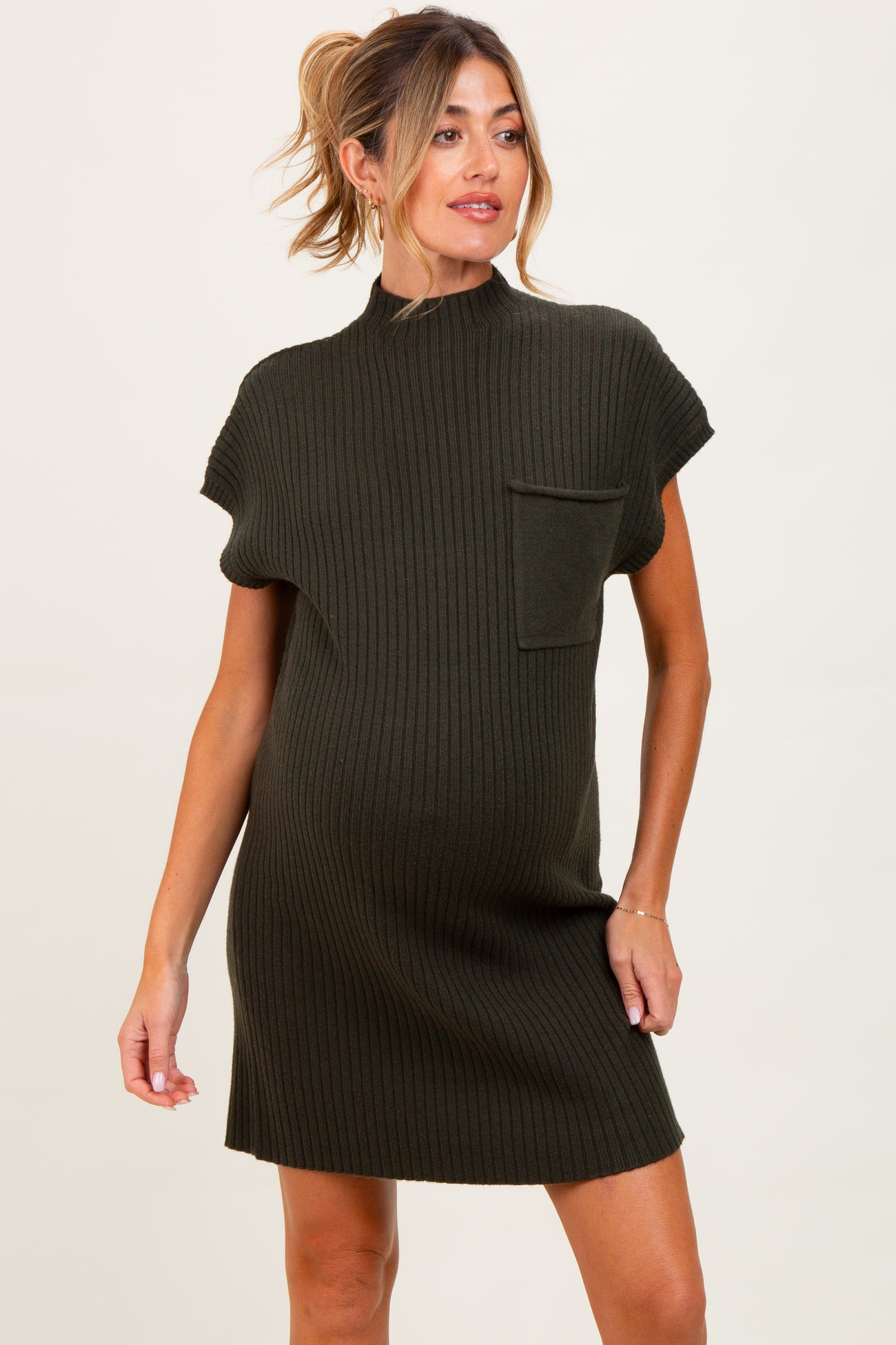 woman wearing a dark green short sleeve ribbed maternity dress with a pocket and visible baby bump