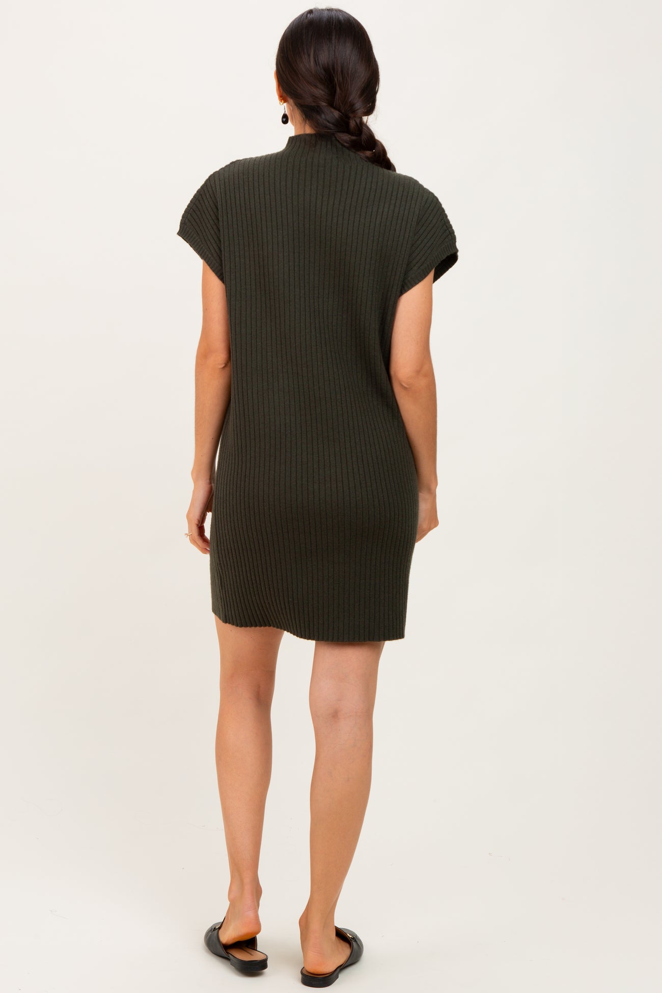 woman wearing a dark green ribbed short sleeve dress, viewed from the back