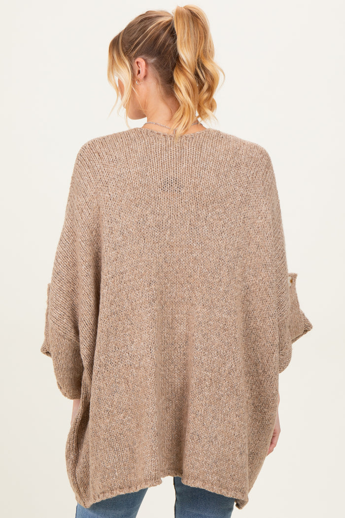 woman wearing a cozy oversized beige maternity sweater with batwing sleeves, viewed from the back
