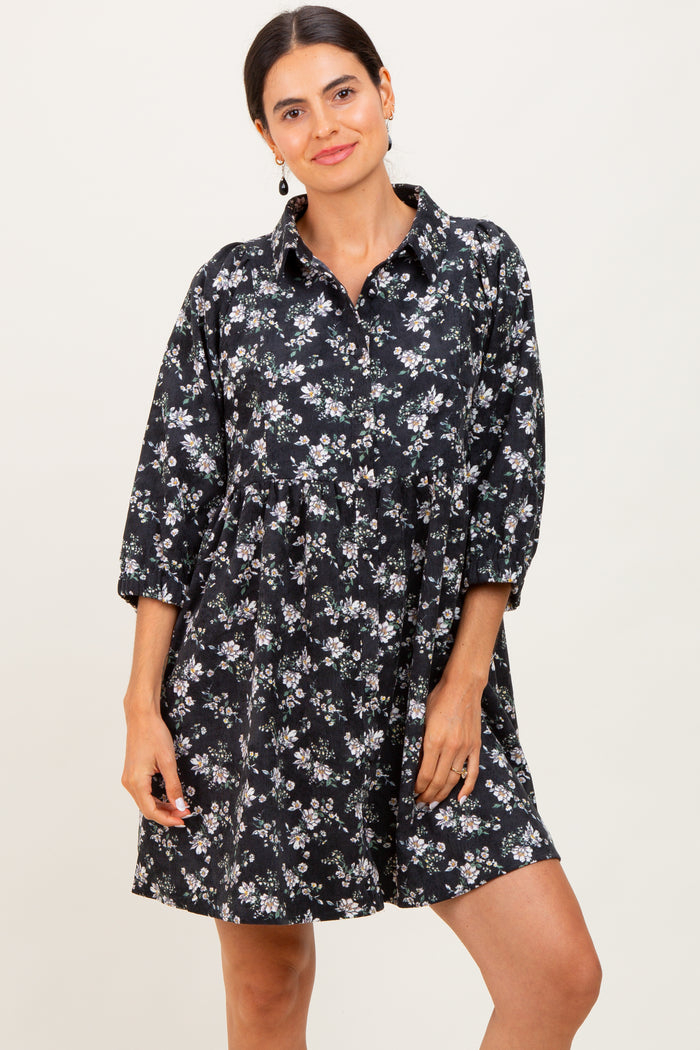 woman wearing a black floral button-up dress with three-quarter sleeves and a relaxed fit