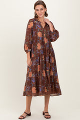 woman wearing a brown floral midi dress with long sleeves and a tiered design
