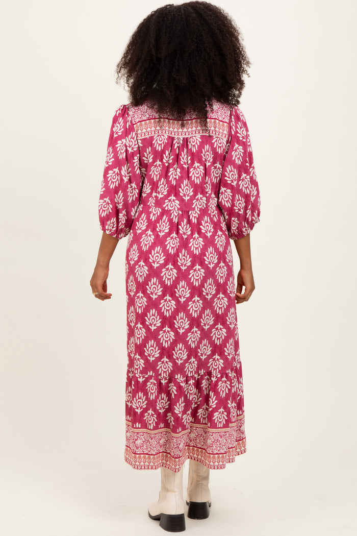 woman wearing a pink floral long sleeve maxi dress with a smocked back and tiered hem