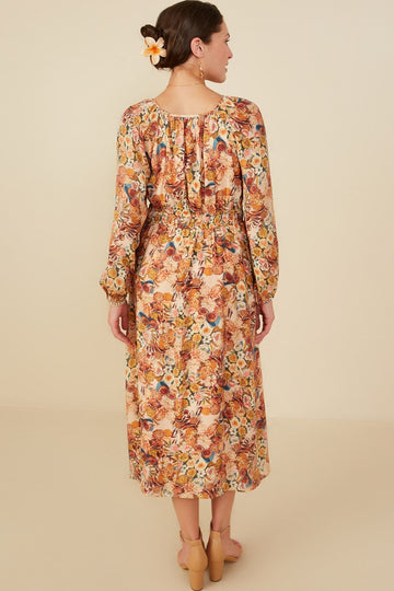 woman wearing a long-sleeve floral midi dress with an elastic waist and gathered back detail