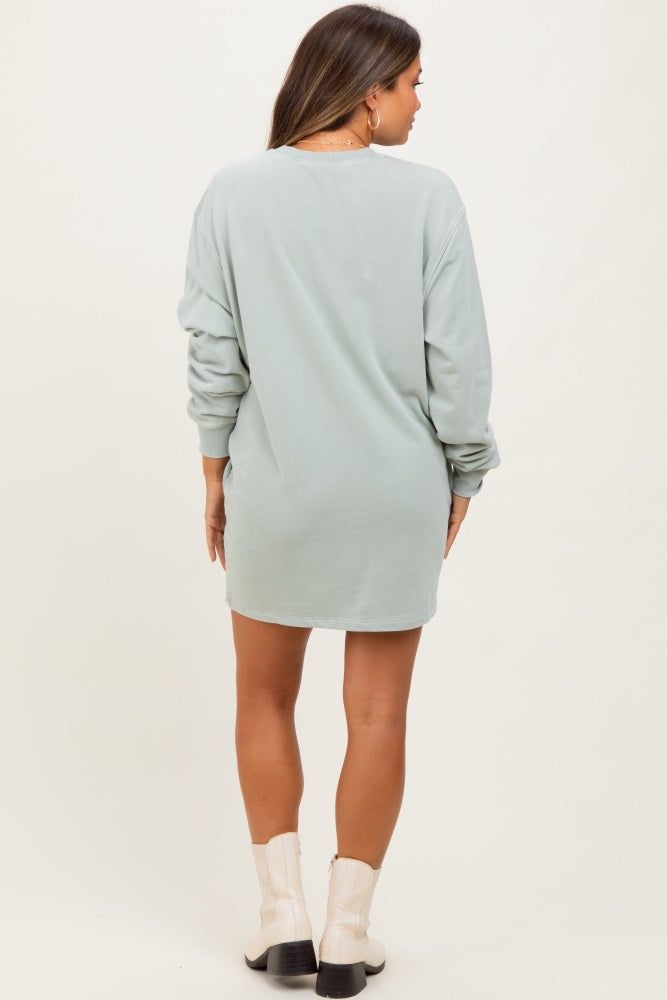 woman wearing a light green long sleeve maternity sweatshirt dress, showing the back view