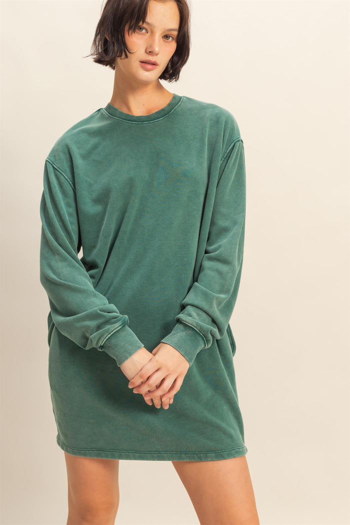 woman wearing a green long sleeve oversized sweatshirt dress with a relaxed fit