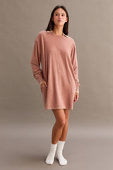 woman wearing a dusty rose long sleeve oversized dress with a collar and side pockets