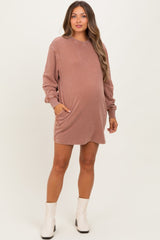 woman wearing a mauve maternity sweatshirt dress with pockets and long sleeves, showing her baby bump