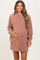 woman wearing a dusty rose oversized maternity sweatshirt dress and holding her baby bump