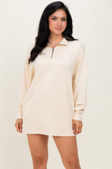 woman wearing a cream long sleeve pullover dress with a zippered collar and relaxed fit