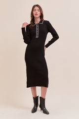 woman wearing a black ribbed knit midi dress with a collar and decorative buttons styled with black ankle boots
