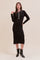 woman wearing a black ribbed knit midi dress with a collar and decorative buttons styled with black ankle boots