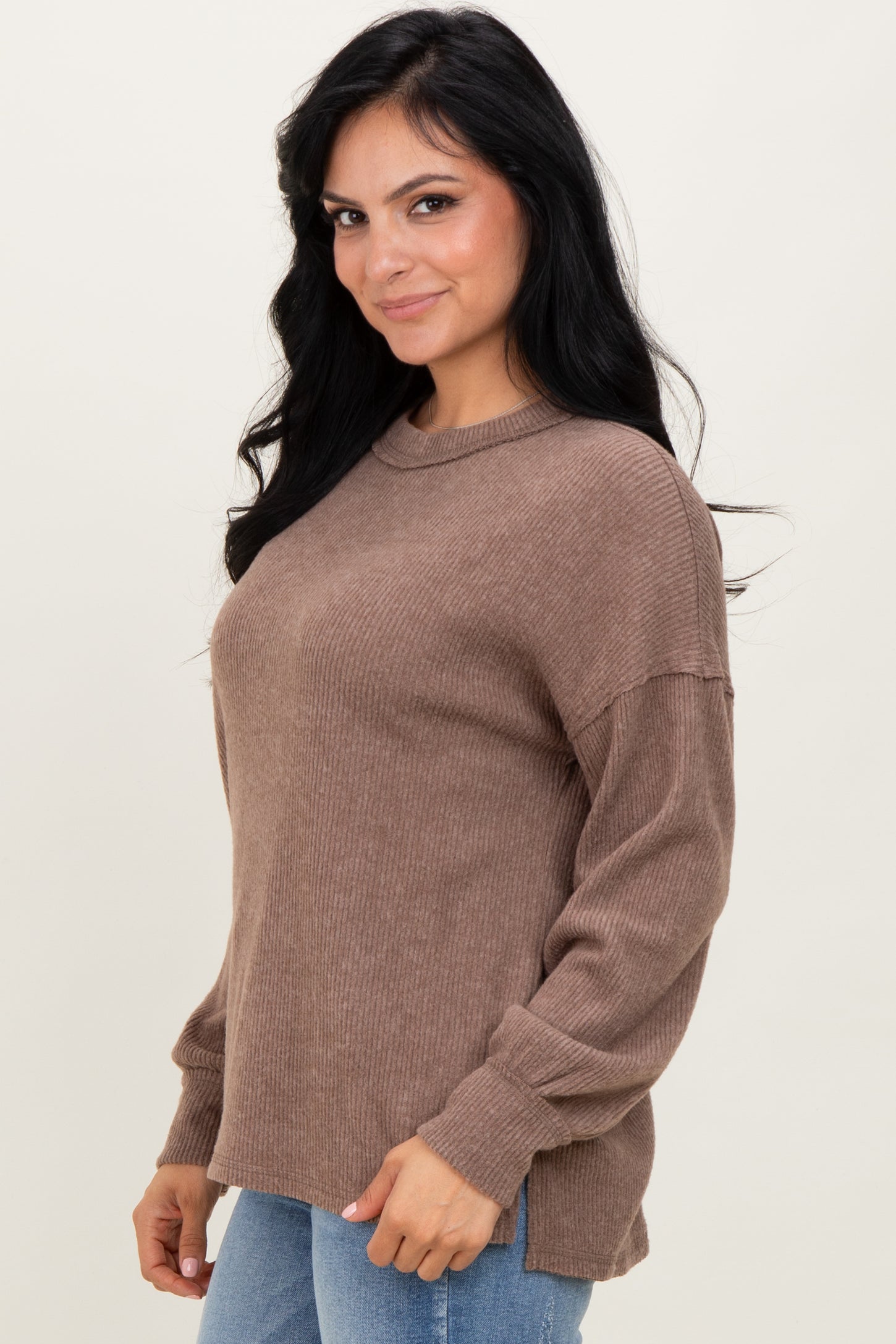 woman wearing a cozy brown ribbed sweater with long sleeves and a relaxed fit