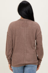 woman wearing a brown ribbed long sleeve sweater, featuring a relaxed fit and dropped shoulders, viewed from the back