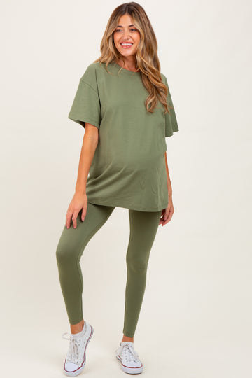 woman wearing an oversized olive green maternity t-shirt and matching leggings, showing her baby bump