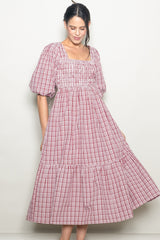 woman wearing a red and white checkered puff sleeve midi dress with a smocked bodice and tiered skirt