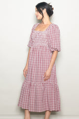 woman wearing a red and white checkered maxi dress with puff sleeves and gathered bodice