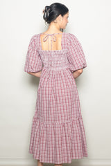 woman wearing a red and white checkered midi dress with puff sleeves and a back tie detail