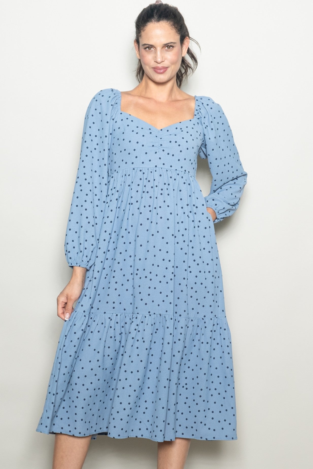 woman wearing a light blue polka dot midi dress with puff sleeves and a square neckline