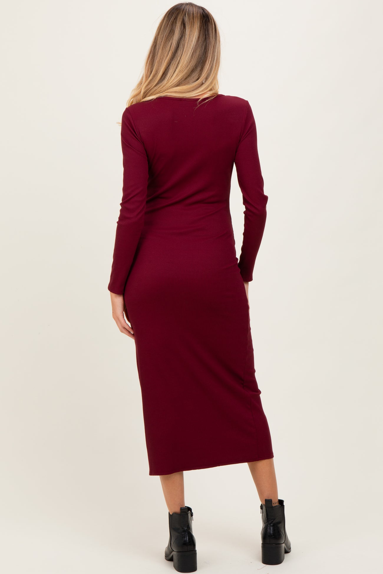 woman wearing a burgundy long sleeve maternity dress, shown from the back, with a fitted silhouette and midi length