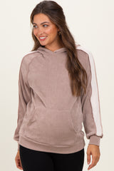 woman wearing a taupe maternity hoodie with a textured fabric and white side stripes, smiling and showing her baby bump