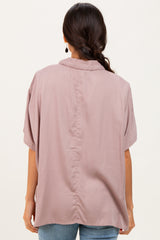 woman wearing a light pink oversized blouse with short sleeves, shown from the back