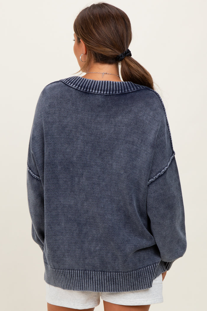 woman wearing a navy blue oversized maternity sweater, viewed from the back, with a ribbed collar and cuffs