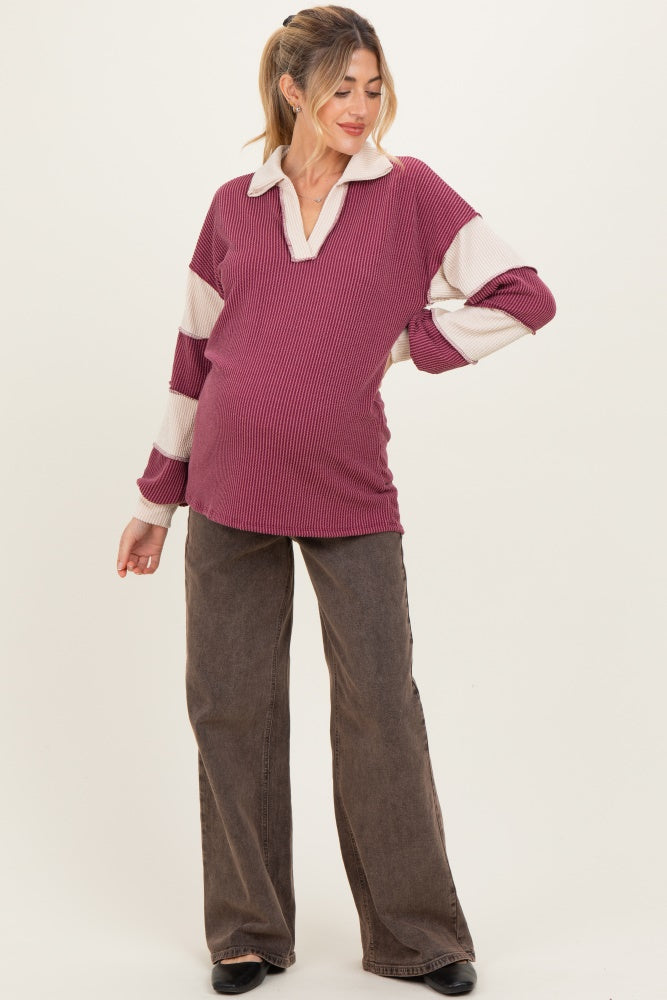 woman wearing a maroon and cream striped maternity top with a collar and a visible baby bump
