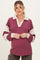 woman wearing a maroon and cream striped maternity top with a collar and long sleeves, showing her baby bump