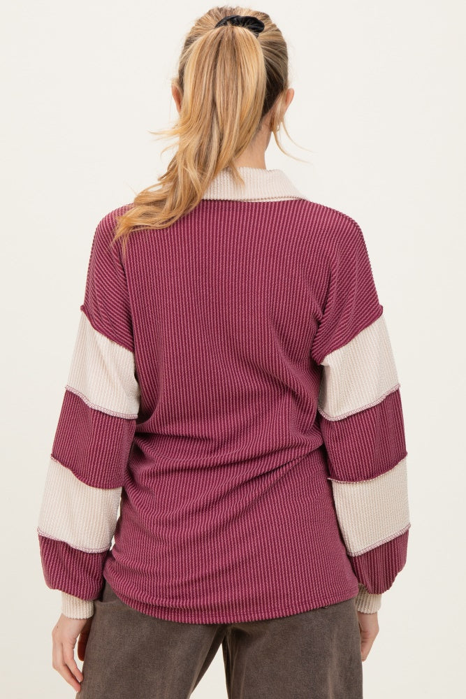 woman wearing a maroon and cream striped long sleeve maternity sweater from the back