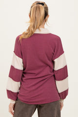 woman wearing a maroon and cream striped long sleeve maternity sweater from the back