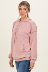 woman wearing a light pink ribbed hoodie with a kangaroo pocket and long sleeves