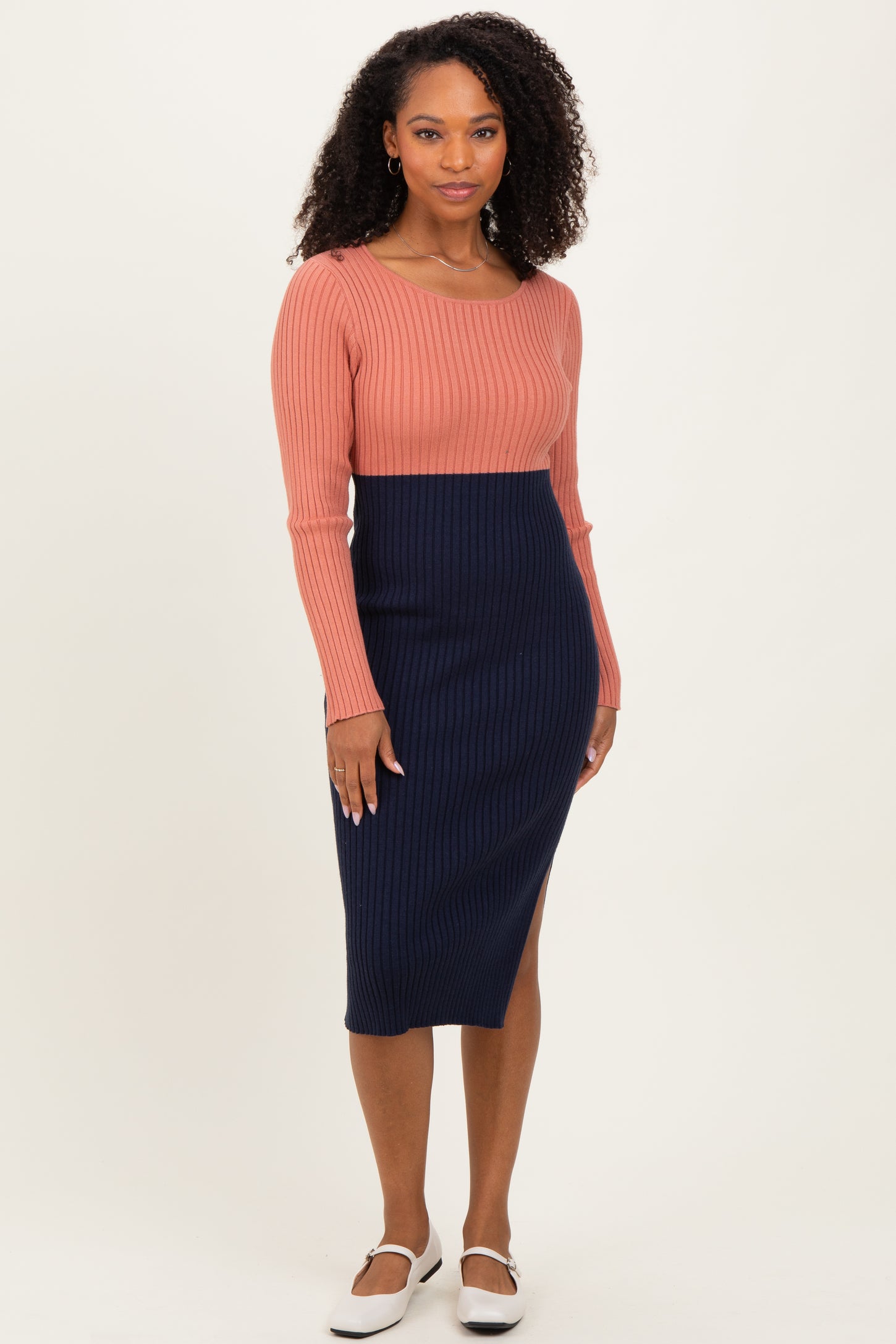 woman wearing a ribbed color block long sleeve dress in coral and navy blue with a fitted silhouette