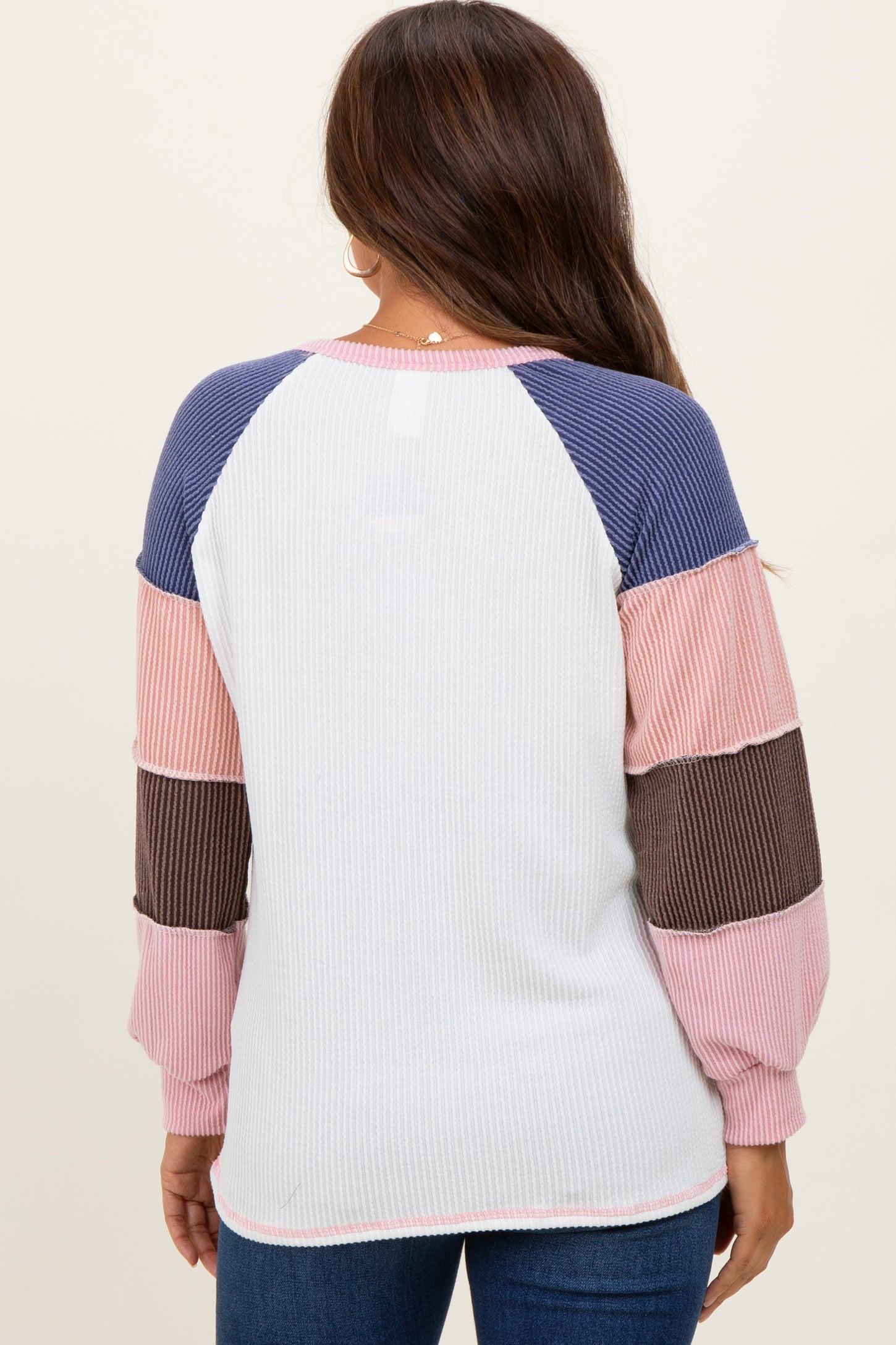 woman wearing a color-blocked ribbed maternity top with long sleeves and a relaxed fit