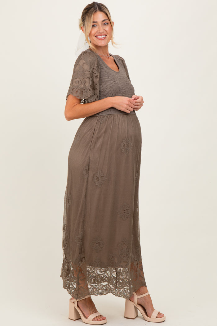 woman wearing a taupe maternity maxi dress with lace embroidery and a visible baby bump